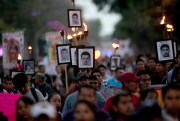 Relatives of the 43 missing students from the Ayotzinapa Rural Teachers’ College march while holding pictures of their loved ones during a protest, Mexico City, Dec. 26, 2015 (AP photo by Marco Ugarte).