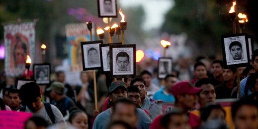Relatives of the 43 missing students from the Ayotzinapa Rural Teachers’ College march while holding pictures of their loved ones during a protest, Mexico City, Dec. 26, 2015 (AP photo by Marco Ugarte).