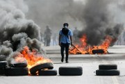 A masked protester walks between burning barricades, Managua, Nicaragua, April 20, 2018 (AP photo by Alfredo Zuniga).