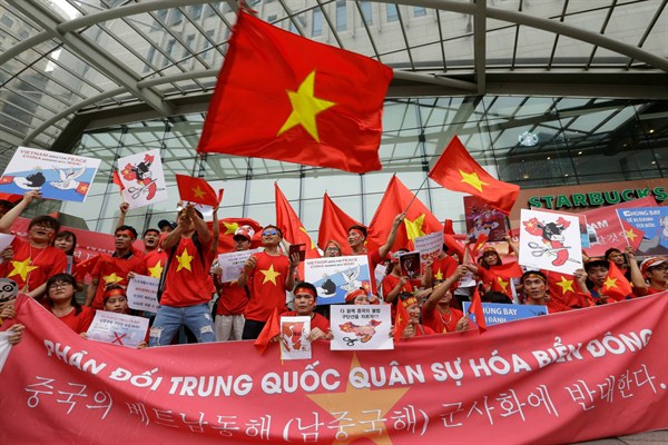 Vietnamese protesters hold national flags and an anti-China banner during a rally near the Chinese Embassy in Seoul, South Korea, July 24, 2016 (AP photo by Ahn Young-joon).