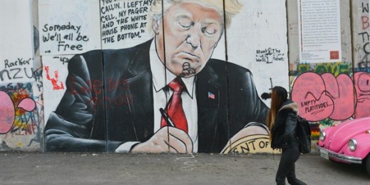 A girl walks by a mural of Donald Trump drawn on Israel’s separation barrier Bethlehem, West Bank, March 13, 2018 (Sipa photo by Artur Widak via AP).