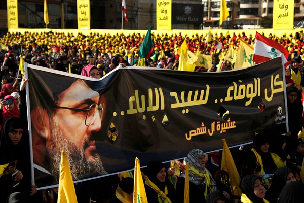 Supporters of Hezbollah leader Hassan Nasrallah hold a banner with his portrait during an election rally, Beirut, Lebanon, April 13, 2018 (AP photo by Hussein Malla).