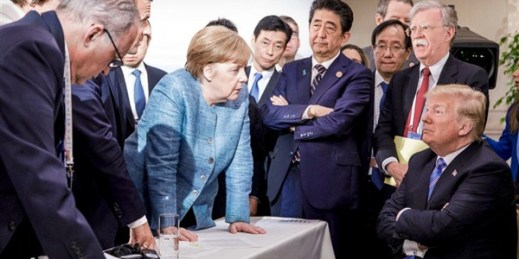 German Chancellor Angela Merkel, surrounded by other G-7 leaders, speaks with U.S. President Donald Trump during the G-7 summit, La Malbaie, Canada, June 9, 2018 (Photo by Jesco Denzel for German Federal Government via AP).