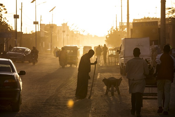 A man sweeps dust off the street at dusk in Agadez, Niger, January 16, 2018 (photo by Joe Penney).
