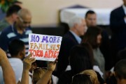 A Venezuelan raises a sign denouncing the separation of families during U.S. Vice President Mike Pence’s visit to the Santa Catarina migrant shelter, Manaus, Brazil, June 27, 2018 (AP photo by Marcio Melo).
