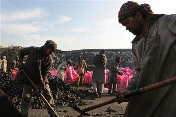 Workers at a trading facility for charcoal from Somalia, in Sharjah, United Arab Emirates, Dec. 5, 2013 (AP photo by Kamran Jebreili).