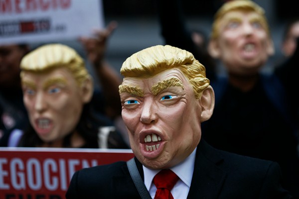 Activists wearing Donald Trump masks protest during NAFTA talks, Mexico City, Feb. 27, 2018 (AP photo by Marco Ugarte).