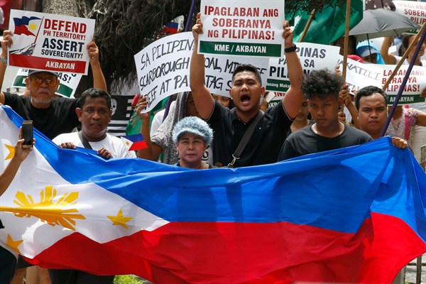 Protesters shout slogans while marching with a Philippine flag toward the Chinese consulate in Manila, Philippines, July 12, 2018 (AP photo by Bullit Marquez).
