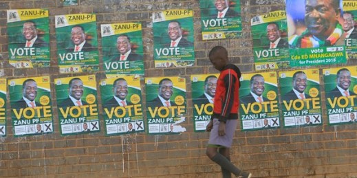 A boy walks past campaign posters for Zimbabwean President Emmerson Mnangagwa, Harare, Zimbabwe, July 25, 2018 (AP photo by Tsvangirayi Mukwazhi).