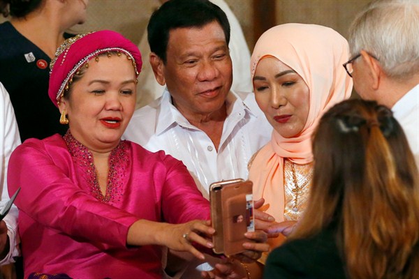 Philippine President Rodrigo Duterte poses for a selfie with Muslim lawmakers following the presentation of the signed Bangsamoro Organic Law at Malacanang Palace in Manila, Philippines, Aug. 6, 2018 (AP photo by Bullit Marquez).