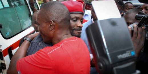 Ugandan pop star Robert Kyagulanyi, better known as Bobi Wine, center, wearing a beret, is hugged by a supporter as he gets into an ambulance after leaving a courthouse in Gulu, Uganda, Aug. 27, 2018 (AP photo).