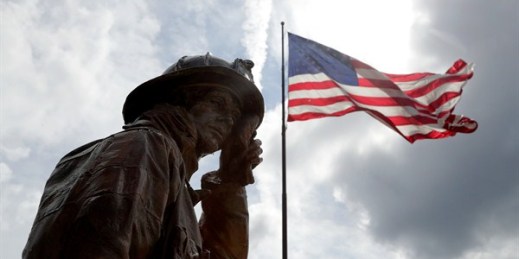 A statue depicting a New York City firefighter wiping sweat from his forehead stands at a display honoring first responders to the 9/11 attacks, Buffalo, N.Y., Aug. 10, 2018 (AP photo by Julio Cortez).