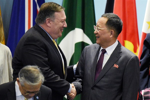 U.S. Secretary of State Mike Pompeo greets North Korean Foreign Minister Ri Yong-ho as they prepare for a group photo at the 25th ASEAN Regional Forum Retreat, Singapore, Aug. 4, 2018 (AP photo by Joseph Nair).