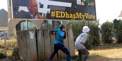 An opposition party supporter throws a rock aimed at a campaign poster for Zimbabwean President Emmerson Mnangagwa, Harare, Zimbabwe, Aug. 1, 2018 (AP photo by Tsvangirayi Mukwazhi).