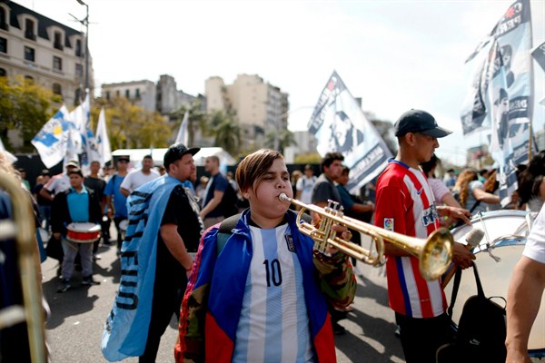 A young demonstrator plays a trumpet during a protest against austerity measures put in place by the government of President Mauricio Macri, Buenos Aires, Sept. 24, 2018 (AP photo by Natacha Pisarenko).