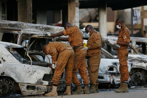 Soldiers examine burnt-out cars outside the Splendid Hotel in Ouagadougou, Burkina Faso, after it was attacked by al-Qaida-linked extremists, Jan. 17, 2016 (AP photo by Sunday Alamba).