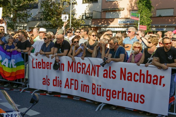 Protesters hold a banner that reads ‘Rather a migrant as a neighbor than the AfD in city hall’, Bensheim, Germany, Sept. 16, 2018 (Photo by Michael Debets for Sipa USA via AP Images).