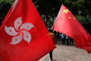 Pro-government protesters hold both the Hong Kong flag, left, and the Chinese national flag outside the convention center, Hong Kong, May 18, 2016 (AP photo by Vincent Yu).