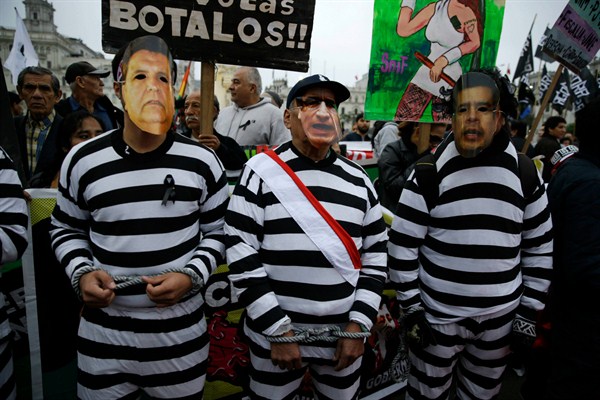 Demonstrators wearing masks with the image of Peru's President Martin Vizcarra, center, former President Alan Garcia, and Congress President Luis Galarreta protest against corruption, in Lima, Peru, on July 27, 2018 (AP photo by Martin Mejia).