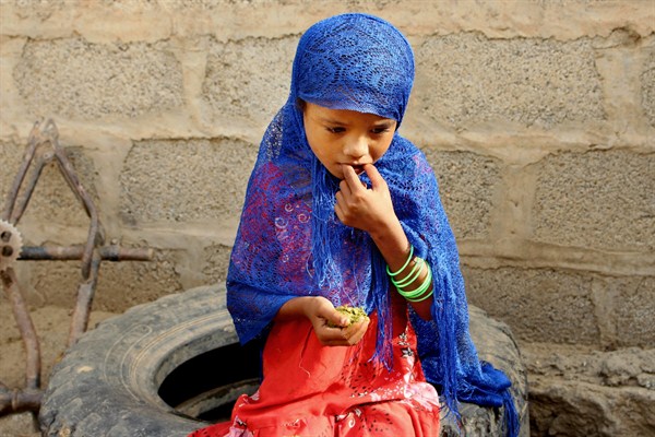 A girl eats boiled leaves from a local vine to stave off starvation, in the extremely impoverished district of Aslam, Hajjah, Yemen (AP photo by Hammadi Issa).