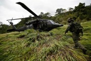 An anti-narcotics police officer runs toward a helicopter after the destruction of a cocaine lab in Calamar, Guaviare state, Colombia, Aug. 2, 2016 (AP photo by Fernando Vergara).