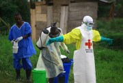 A health worker sprays disinfectant on his colleague after working at an Ebola treatment center in Beni, eastern Congo, Sept. 9, 2018 (AP photo by Al-hadji Kudra Maliro).
