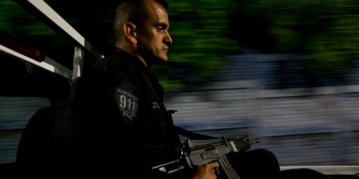 Police officer Jorge Alberto Canizalez watches the streets from the back of a pickup during a nighttime patrol in San Salvador, El Salvador, Aug. 21, 2018 (AP photo by Rebecca Blackwell).