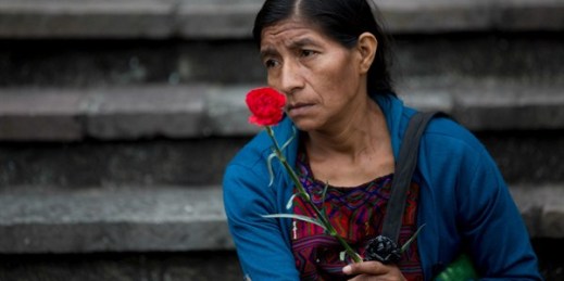 An Ixil woman holds a red carnation during a memorial ceremony for victims of Guatemala’s civil war, Guatemala City, Sept. 26, 2018 (AP photo by Moises Castillo).