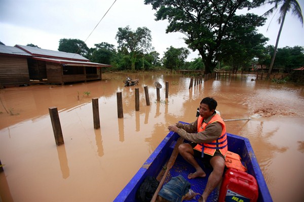 A man paddles his boat through a flooded village in the Sanamxay district, Attapeu province, Laos, July 26, 2018 (AP photo by Hau Dinh).