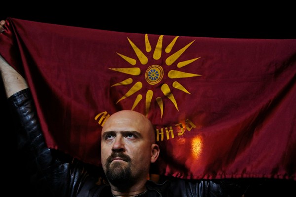 A supporter of a movement for voters to boycott the Macedonian referendum holds an old Republic of Macedonia flag during celebrations in central Skopje, Sept. 30, 2018 (AP photo by Thanassis Stavrakis).