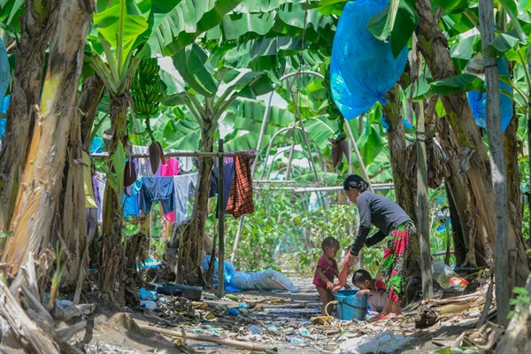 A family bathes in one of the irrigation ditches at a hideout in a banana plantation on the island of Mindanao, Philippines (Lindsay Fendt).