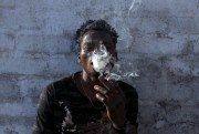 A Malawian migrant smokes marijuana on the rooftop of an abandoned building in downtown Johannesburg, South Africa, March 29, 2018 (AP photo by Bram Janssen).