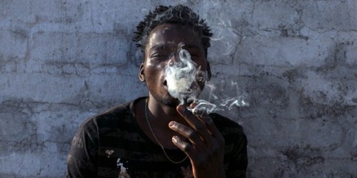 A Malawian migrant smokes marijuana on the rooftop of an abandoned building in downtown Johannesburg, South Africa, March 29, 2018 (AP photo by Bram Janssen).