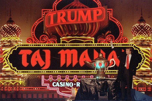 Donald Trump stands next to a genie’s lamp as the lights of his Trump Taj Mahal Casino Resort light up during its opening in Atlantic City, N.J., April 5, 1990 (AP photo by Mike Derer).