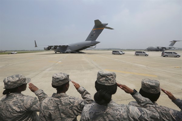 U.S. Army soldiers salute as vehicles carry what are believed to be remains from American servicemen killed during the Korean War, Osan Air Base, Pyeongtaek, South Korea, July 27, 2018 (AP photo by Ahn Young-joon).