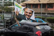 A supporter waves a flag with an image of President-elect Jair Bolsonaro, Rio de Janeiro, Brazil, Oct. 29, 2018 (AP photo by Leo Correa).