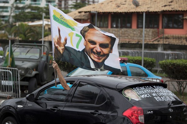 A supporter waves a flag with an image of President-elect Jair Bolsonaro, Rio de Janeiro, Brazil, Oct. 29, 2018 (AP photo by Leo Correa).