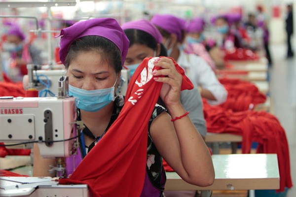 Garment workers sew clothes in a factory as they wait for a visit by Prime Minister Hun Sen outside of Phnom Penh, Cambodia, Aug. 30, 2017 (AP photo by Heng Sinith).
