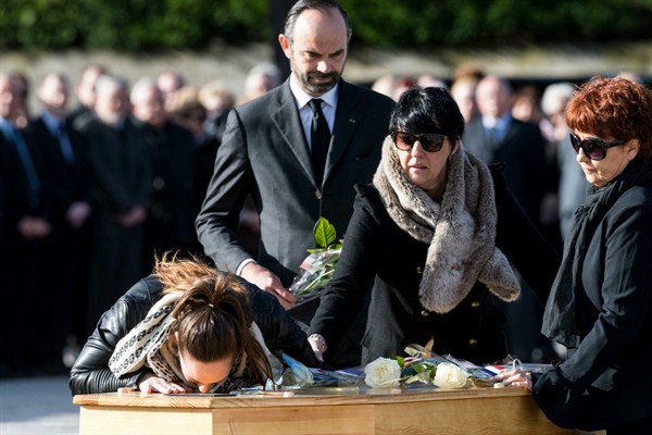 A daughter of Christian Medves kisses her father’s coffin during a ceremony for three victims of an extremist gun rampage in March 2018 in Trebes, southern France, March 29, 2018 (AP photo by Fred Lancelot).