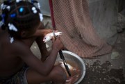 A girl removes scales from a fish in her home in Belle Anse, Haiti, May 22, 2013 (AP photo by Dieu Nalio Chery).