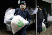 A city employee carries a bag of seized cocaine to be destroyed at a police base, Lima, Peru, June 7, 2018 (AP photo by Martin Mejia).