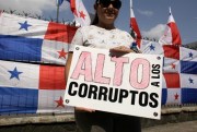 A demonstrator holds a sign that reads in Spanish “Stop the corrupted” outside the National Assembly in Panama City, Panama, March 11, 2018 (AP photo by Arnulfo Franco).