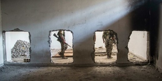 Members of the U.S.-backed Syrian Democratic Forces walk inside the stadium that was the site of Islamic State fighters’ last stand in the city of Raqqa, Syria, Oct. 20, 2017 (AP photo by Asmaa Waguih).
