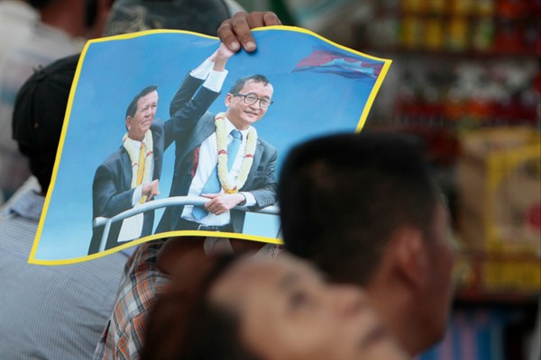 Supporters of the Cambodia National Rescue Party hold a poster of Sam Rainsy and Kem Sokha during the last day of campaigning for the June 4 commune elections, Phnom Penh, Cambodia, June 2, 2017 (AP photo by Heng Sinith).
