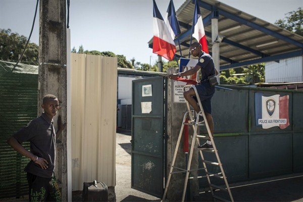 A young migrant stands in front of the Administrative Detention Center in Pamandzi, Mayotte, June 19, 2015 (Photo by Andrieu Arnaud for Sipa via AP Images).