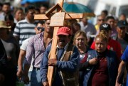 A man carries a cross during the funeral procession of a person who died when a gas pipeline exploded, Tlahuelilpan, Mexico, Jan. 20, 2019 (AP photo by Claudio Cruz).