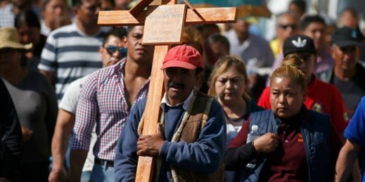 A man carries a cross during the funeral procession of a person who died when a gas pipeline exploded, Tlahuelilpan, Mexico, Jan. 20, 2019 (AP photo by Claudio Cruz).