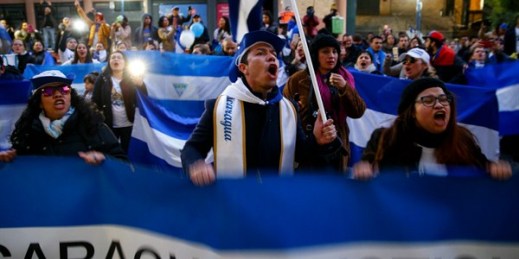 Demonstrators shout slogans and wave Nicaraguan flags during a protest against the Nicaraguan government in front of the Nicaraguan Embassy in Madrid, Spain, Jan. 12, 2019 (AP photo by Andrea Comas).