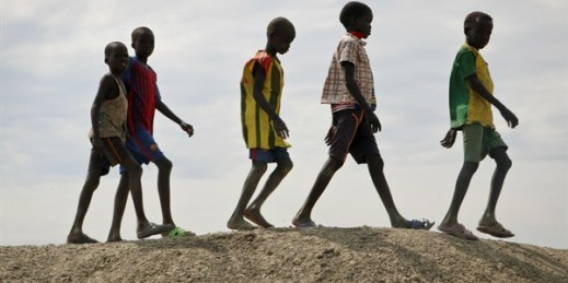 A group of children walk on top of a small hill of dirt in the United Nations protection of civilians site in Bentiu, South Sudan, Dec. 9, 2018 (AP photo by Sam Mednick).