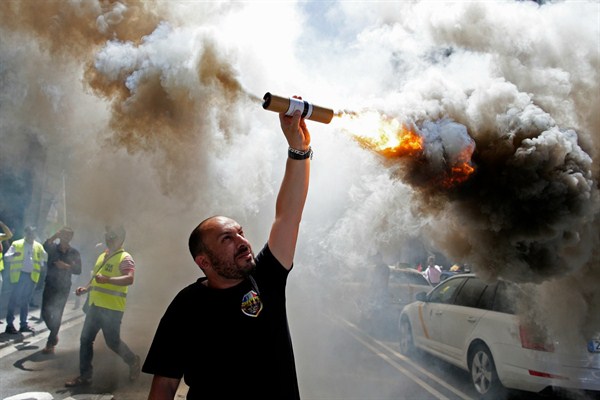 A protester burns a flare during a taxi strike, Barcelona, Spain, June 29, 2017 (AP photo by Manu Fernandez).